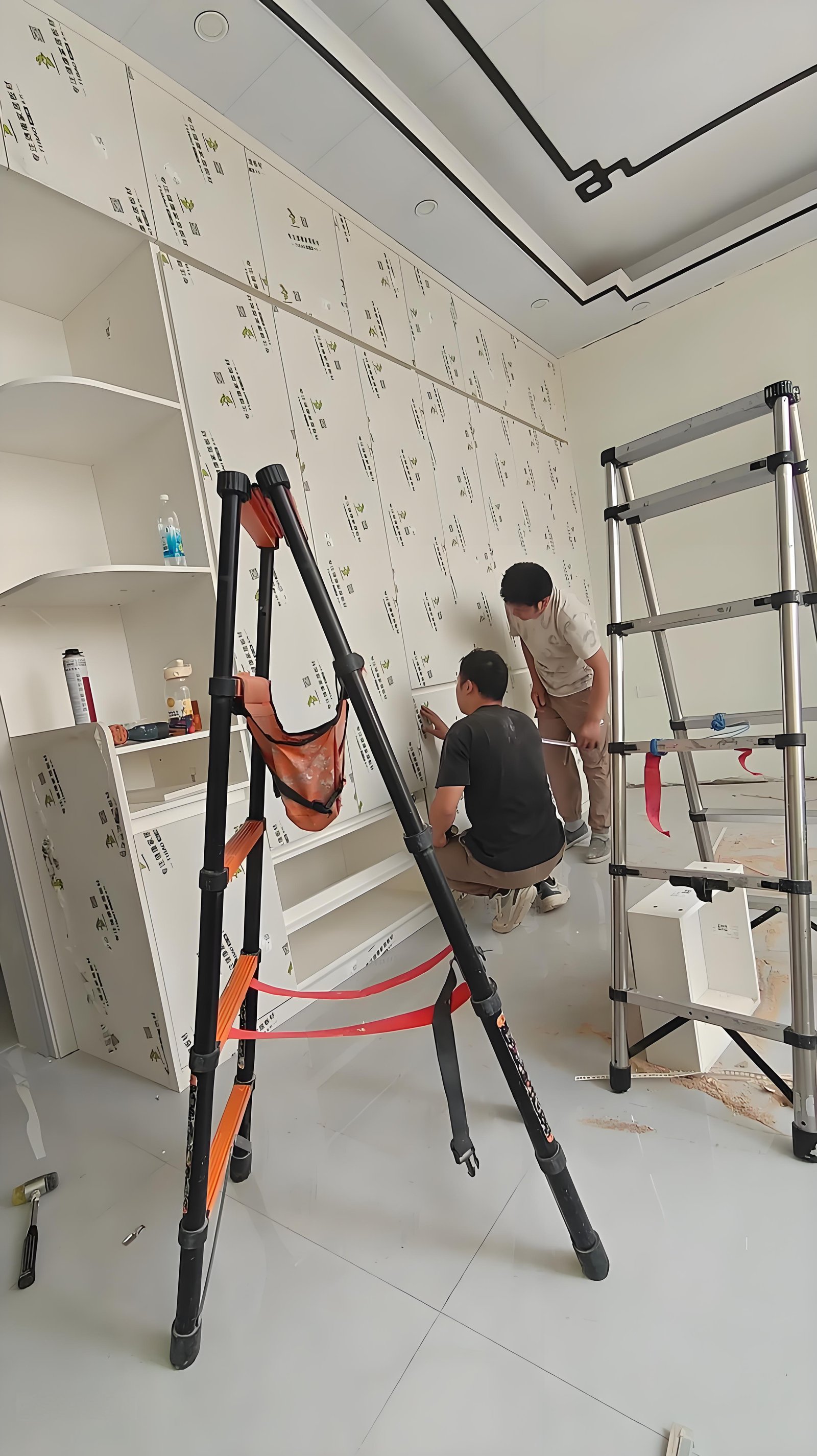 Professional furniture installers working on custom cabinet installation in Kampala home